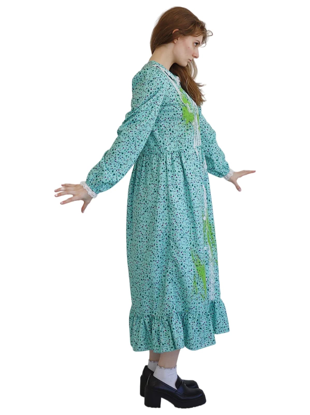 Woman in a long aqua speckled dress with white lace panels and green splatter stains